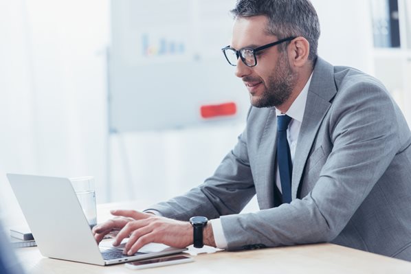 salesperson sending a quote to a customer on his laptop